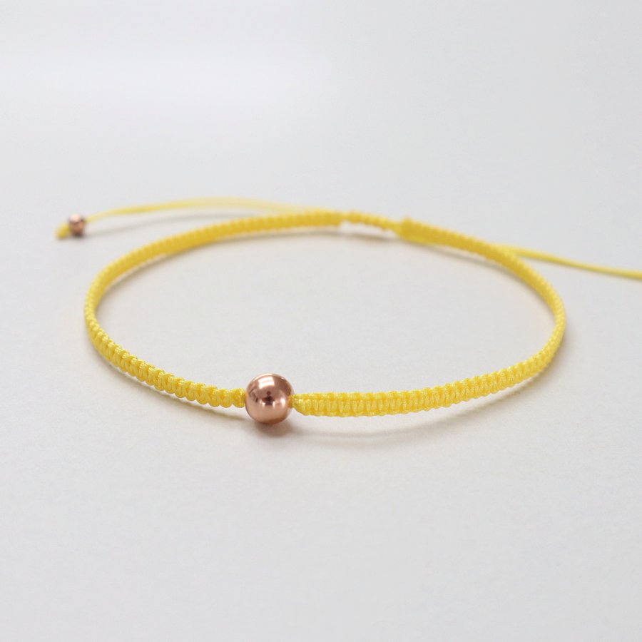 Håndknyttet armbånd i lækker solgul farve med rosaguldskugle